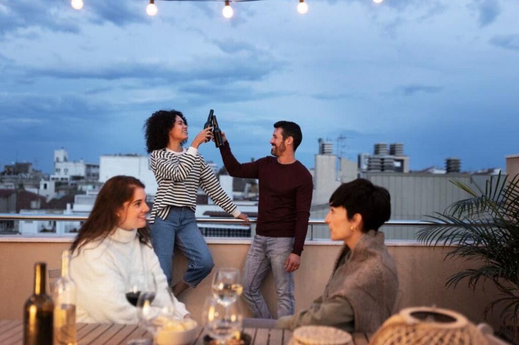 Friends toasting on a rooftop at dusk with city views