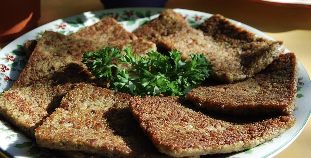 Livermush dish on a plate with greens
