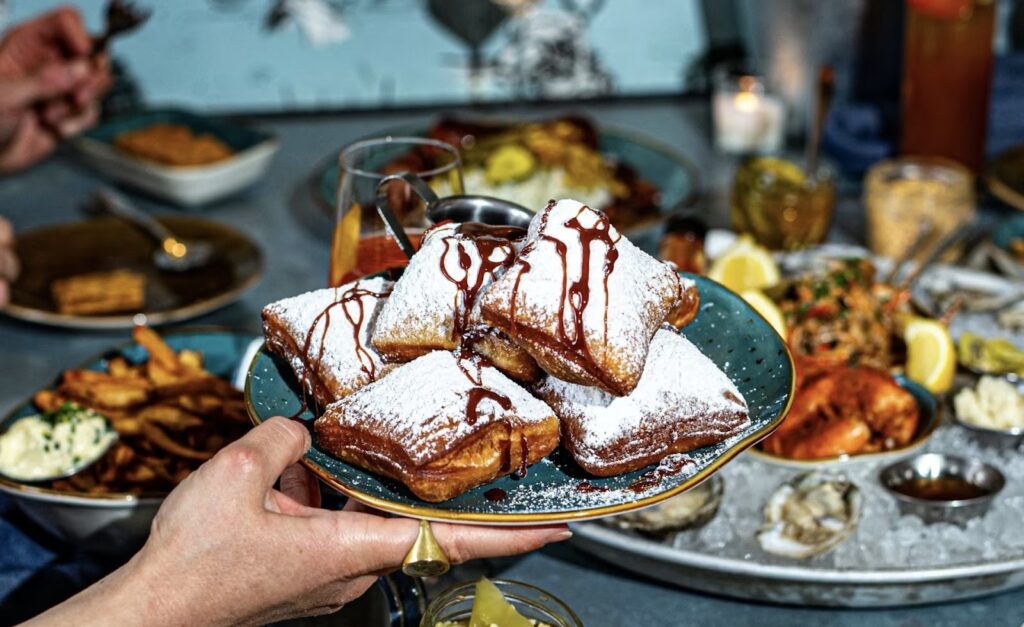 Hand holding a plate with cakes